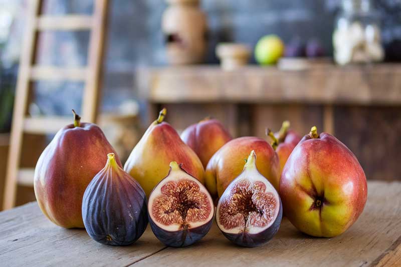 Coings et figues frais sur une table en bois.