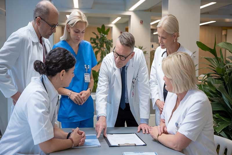 Personnel médical discutant de plans de traitement de chimiothérapie dans un hôpital.