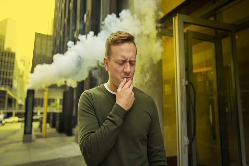 Personne dans un environnement avec de la fumée et des vapeurs toxiques.