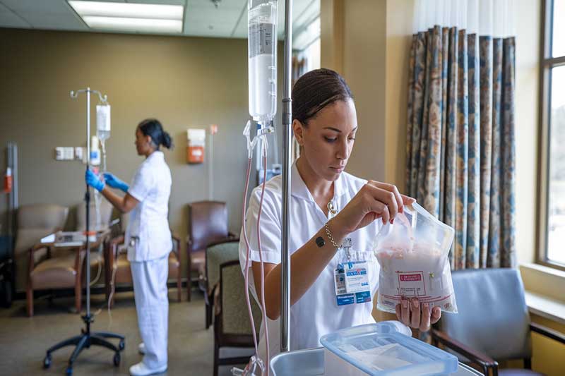 Équipe médicale préparant un traitement de chimiothérapie dans un cadre hospitalier.