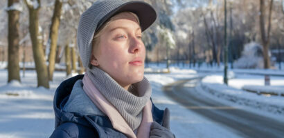 Personne marchant dans un parc ensoleillé en hiver.